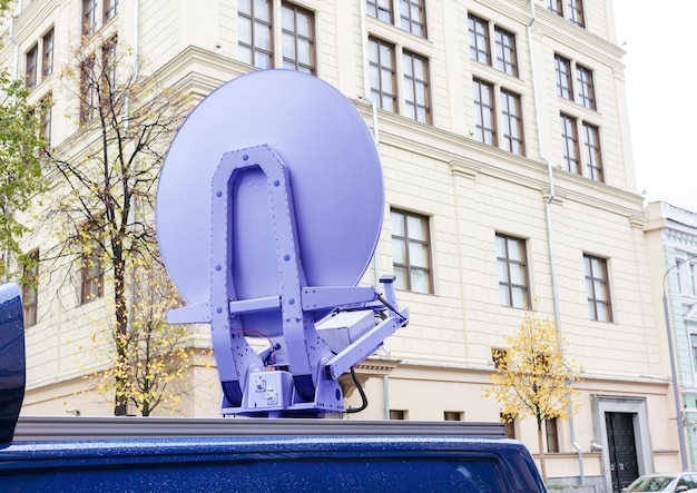 Antena parabólica no telhado do prédio do carro ao fundo