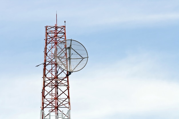 Antena parabólica en la torre de antena de radio de telecomunicaciones con cielo azul