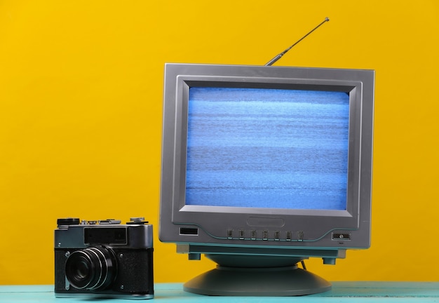 Antena receptor de tv retro antiguo con cámara de película en amarillo.