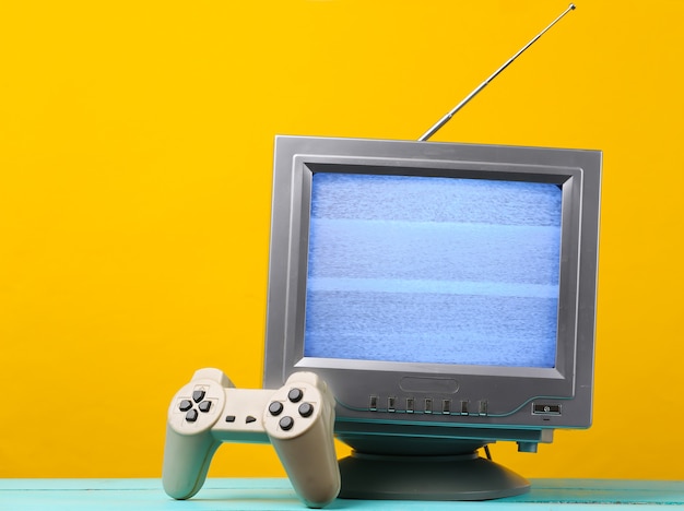 Antena receptor de tv retro antiguo con gamepad en amarillo.