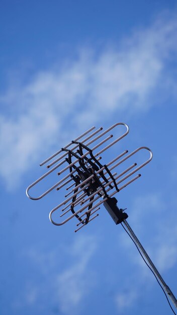 Foto una antena de tv con un cielo azul y nubes en el fondo