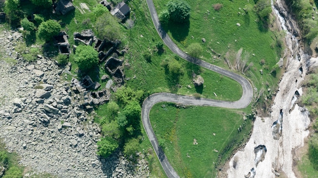 Antena: vista de arriba hacia abajo sobre una sinuosa carretera de montaña en los Alpes italianos.