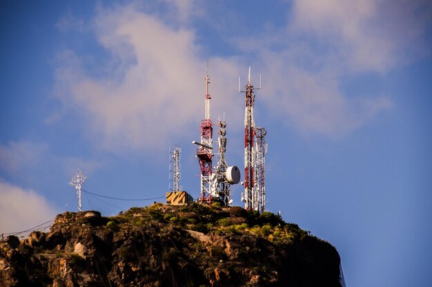 Antenas blancas y rojas en la cima de una colina