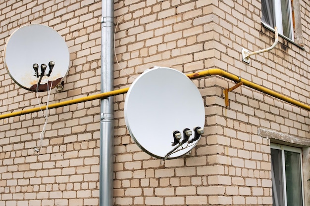 Antenas parabólicas en la pared del edificio