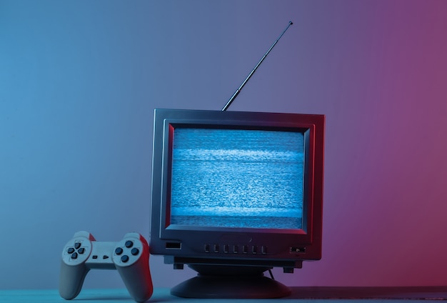Antenne altmodischer Fernsehempfänger mit Gamepad in rosa blauem Neonlicht mit Farbverlauf Retro-Medienunterhaltung 80er Jahre Retro-Welle