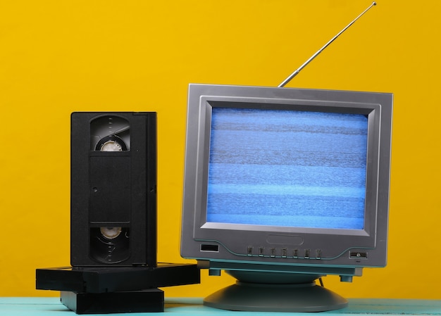Antenne altmodischer Retro-TV-Empfänger und Videokassetten auf Gelb.