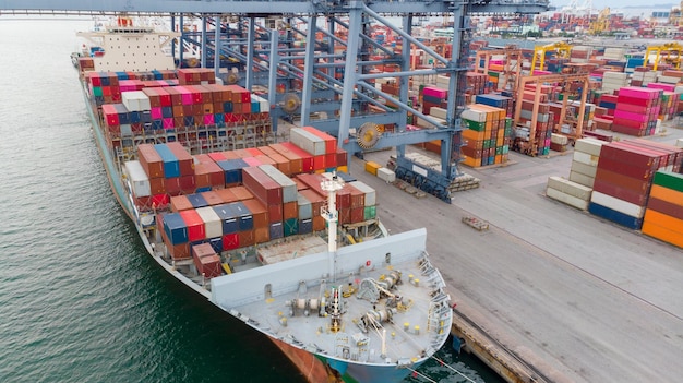 Antenne des Frachtcontainerschiffs, das Container unter einem großen Kran trägt, der Frachtimport- und Exportservice-Transportkonzept lädt