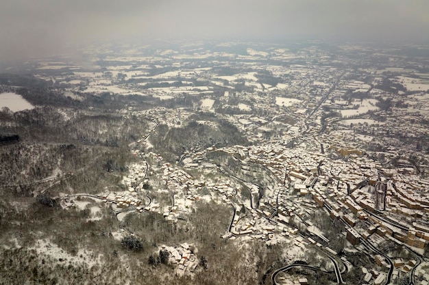 Antenne Winterlandschaft des dichten historischen Zentrums der Stadt Thiers im Departement PuydeDome Region AuvergneRhoneAlpes in Frankreich Dächer von alten Gebäuden und engen Gassen bei Schneefall