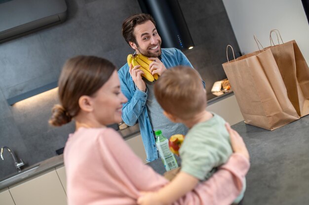 Antes do café da manhã. Família jovem olhando feliz enquanto se prepara para comer algo