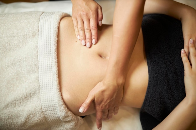 Anti-Cellulite-Massage des Bauches Die Hände des Masseurs massieren den Bauch einer Frau