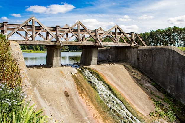 Antiga barragem com ponte de madeira. vista da paisagem ensolarada de verão.