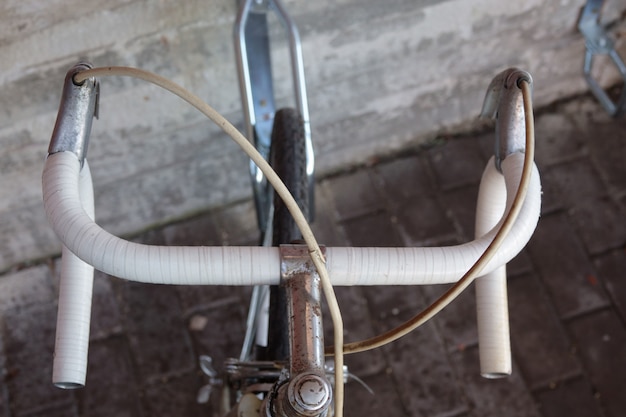 Foto antiga bicicleta vintage enferrujada perto do muro de concreto