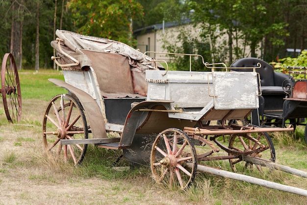 Antiga carruagem em um pátio rural em um dia de verão