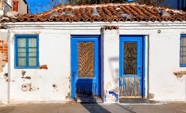 Antiga casa abandonada com portas azuis em siviri, halkidiki, grécia