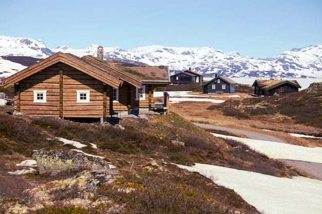 Antiga casa de madeira tradicional norueguesa em Tyin e montanhas ao fundo, Noruega