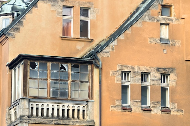 Antiga casa de pedra marrom com janelas quebradas