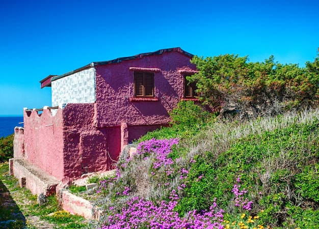 Antiga casa rosa no mar