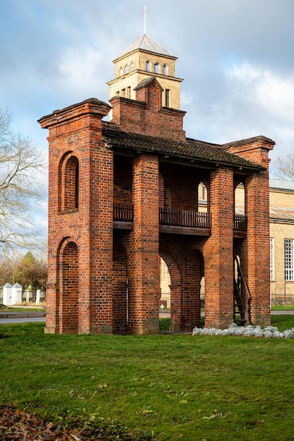 Antiga Igreja Católica e portões de tijolos vermelhos na cidade de Akniste Letônia