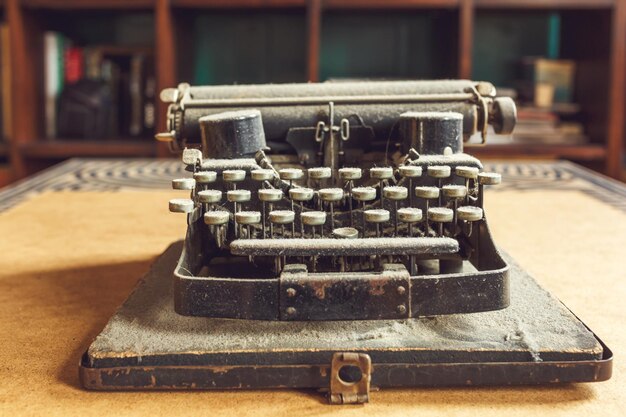 Foto antiga máquina de escrever coberta de poeira com folha de papel branco