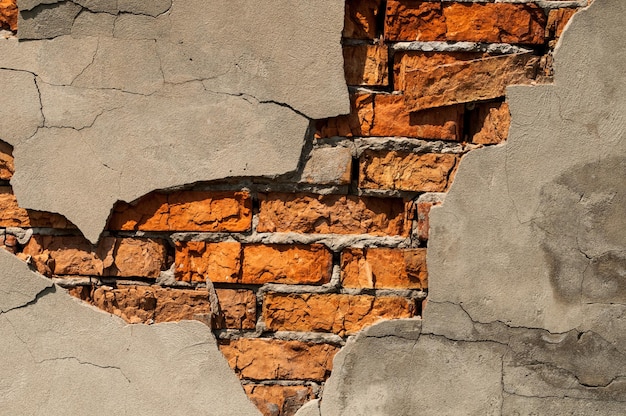 Antiga parede de tijolos com gesso caído Fundo da textura da parede de tijolos rachados