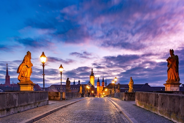 Antiga ponte principal, Alte Mainbrucke com estátuas de santos, catedral e prefeitura na cidade velha de Wurzburg ao pôr do sol, Francônia, Baviera, Alemanha