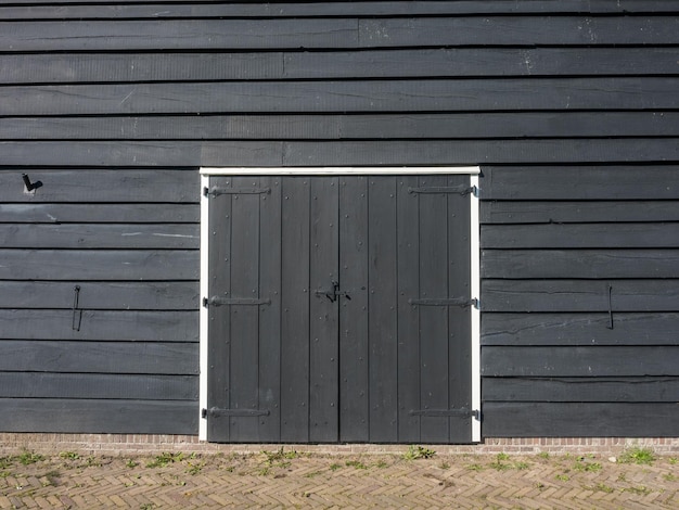 Antiga porta de celeiro de madeira escura clássica em campo ao ar livre