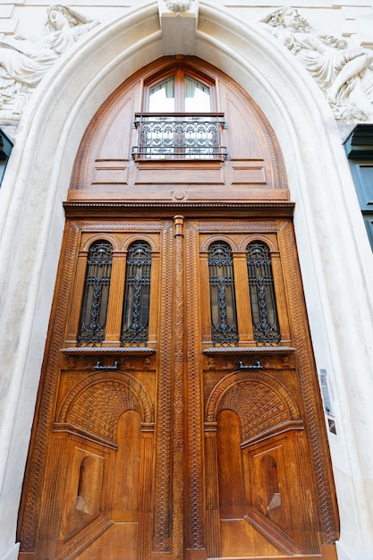 Antiga porta ornamentada no edifício de apartamentos antigo típico de Paris