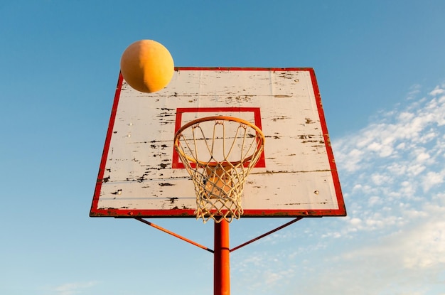 Antiga tabela de basquete e uma bola voando para a cesta