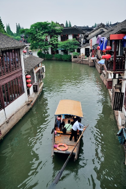 Antiga vila pelo rio em xangai com barco