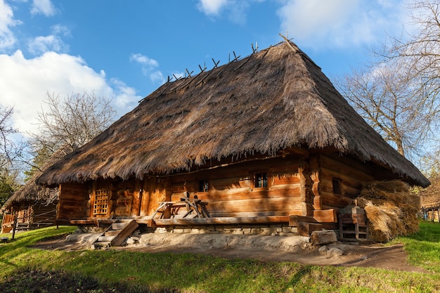 Antigas casas de madeira com telhado de palha, antiga casa rural ucraniana tradicional com telhado de palha