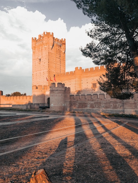 Antigo castelo medieval com fosso em frente ao pôr do sol na Espanha