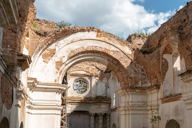 Antigo edifício dilapidado em ruínas com colunas de tijolo vermelho Uma antiga igreja ou igreja com afrescos nas paredes Valor histórico e patrimônio da Maçonaria