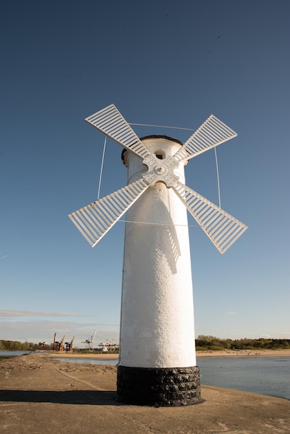 Antigo farol em Swinoujscie um porto na Polônia, no Mar Báltico O farol foi projetado como um moinho de vento tradicional Imagem panorâmica farol antigo moinho