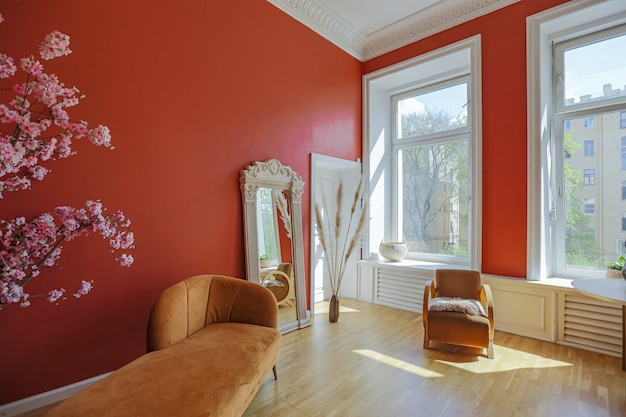 Antigo interior vintage em sala de estar em estilo do século 19 com paredes vermelhas brilhantes, piso de madeira e luz solar direta dentro do quarto.