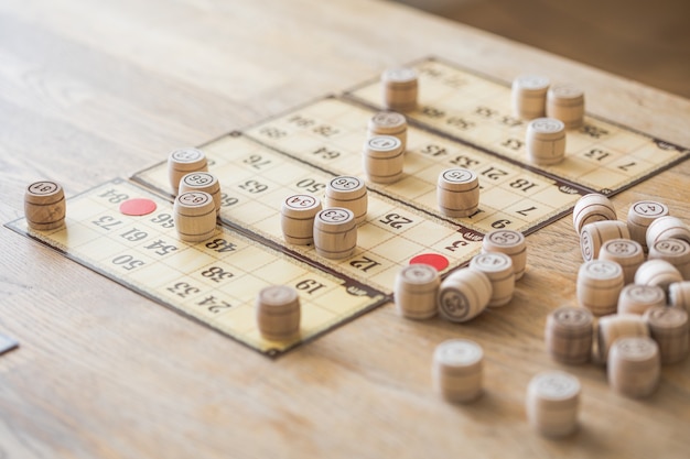 Foto antigo jogo de loteria de mesa com elementos de madeira. cartões de bingo.