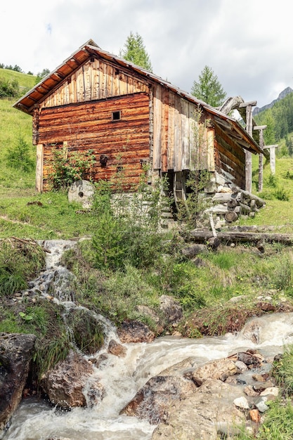 Antigo moinho de água nas margens de um riacho na montanha em um parque Mill Valley Val di Morins Longiaru