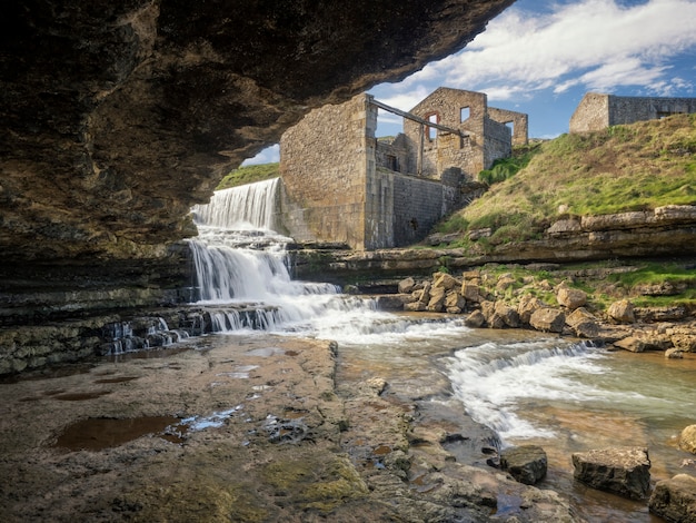 Antigo moinho e cachoeira, vista de uma caverna