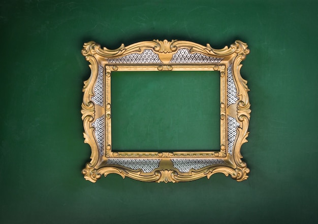 Antigo quadro decorativo dourado vitoriano em uma parede verde barroco rococó o renascimento