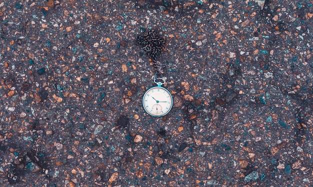 Antigo relógio de bolso no chão. Conceito de tempo.