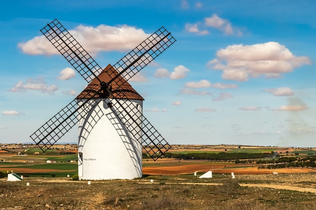 Antigos moinhos de vento brancos, feitos de pedra, no campo com céu azul e nuvens brancas. La Mancha, Castilla, Espanha. Europa.