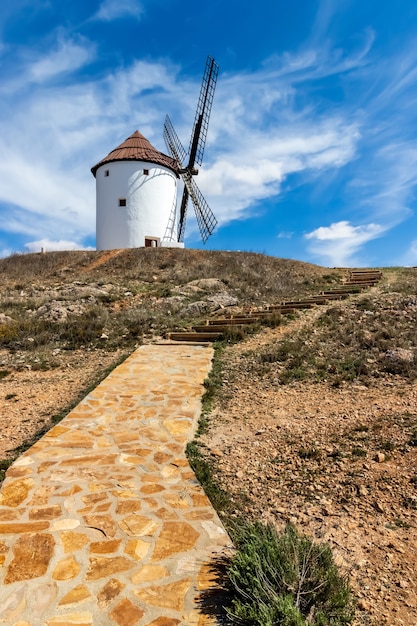 Antigos moinhos de vento brancos, feitos de pedra, no campo com céu azul e  nuvens brancas. la mancha, castilla, espanha. europa.