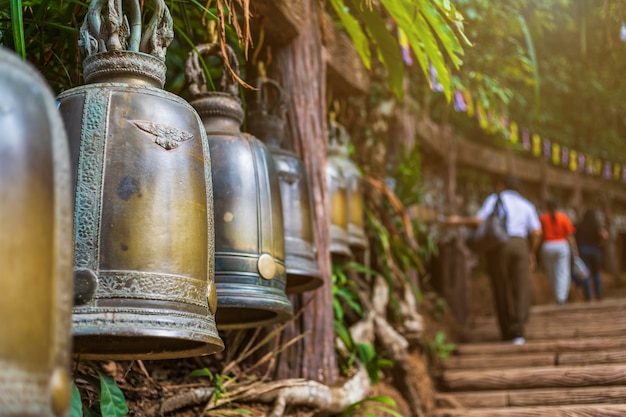 Antigua campana cuelga en un riel de acero en la piedra con la huella de lord buddha