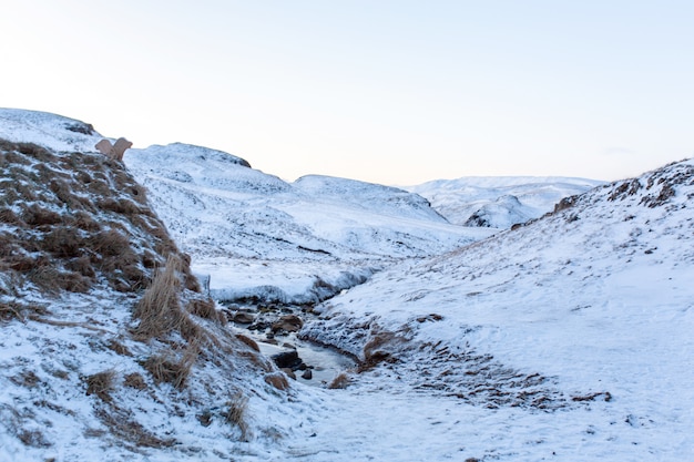 Una antigua casa de baños con aguas termales en las montañas de Islandia. Paisaje de invierno de Islandia