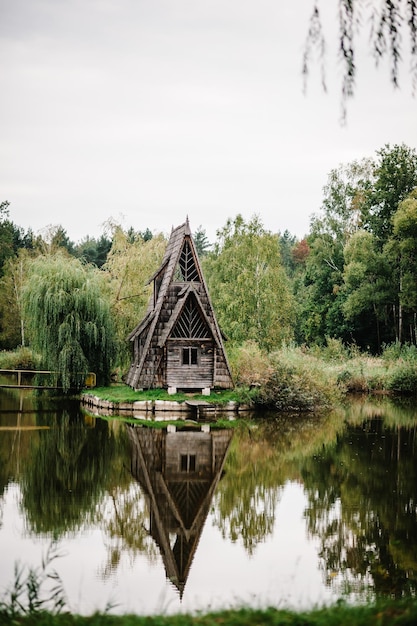 Una antigua casa de madera en la isla en medio del lago un puente de madera que cruza el río Naturaleza