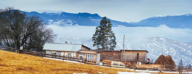 Antigua casa de madera en las montañas en un clima brumoso