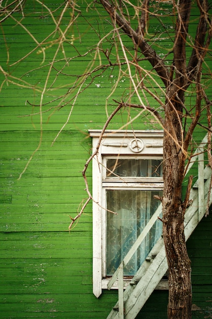 Antigua casa de madera con pared verde