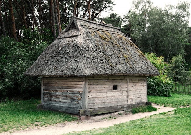 Antigua casa de madera en el pueblo del siglo XIX en medio del bosque.