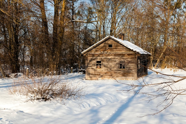 Una antigua casa rural de madera en invierno.