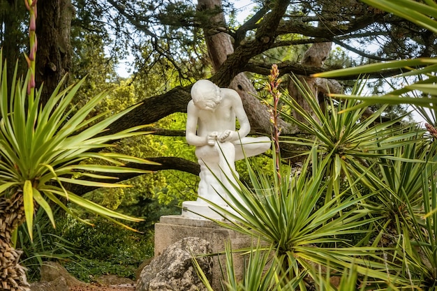 Una antigua escultura de un niño sacando una astilla de su pierna en el Jardín Botánico Nikitsky