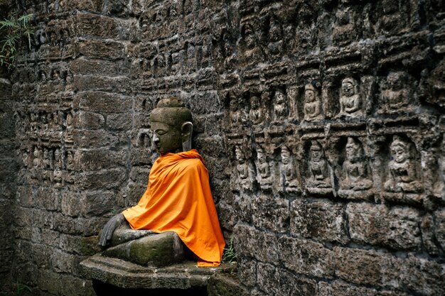 Antigua estatua de Buda en tapa naranja